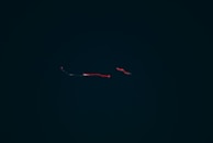 Dark background with subtle blue light trails resembling data flow in space.