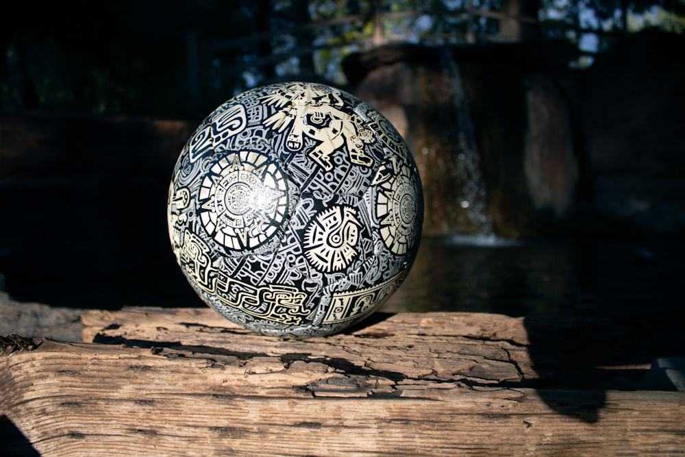 a ball sitting on top of a wooden log