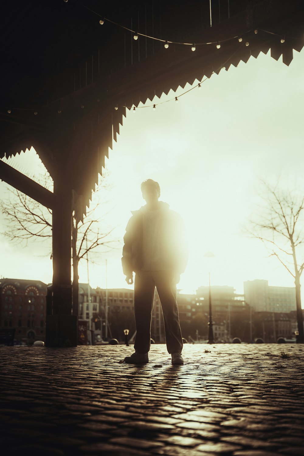 a man standing under a covered structure in the sun