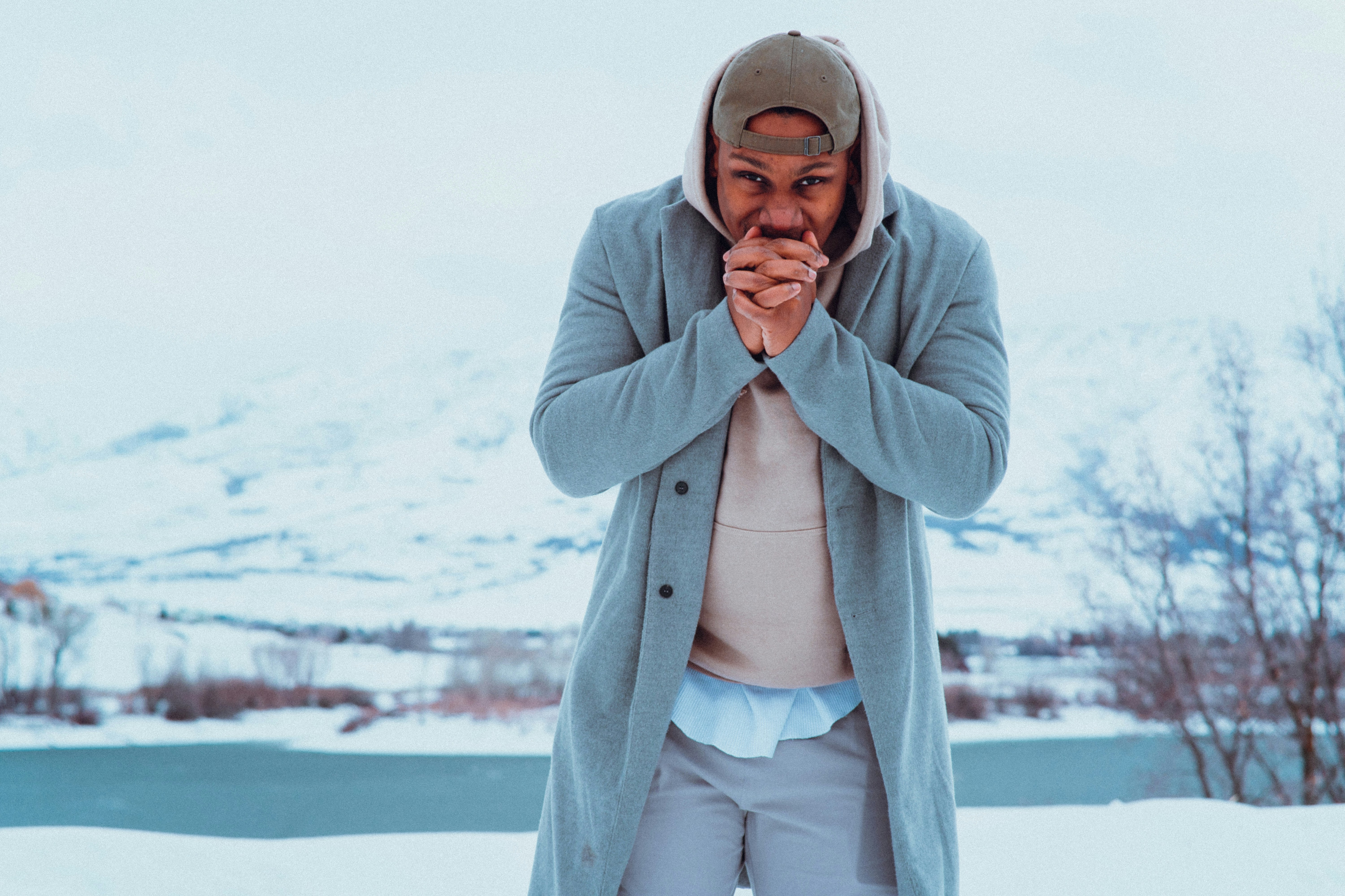Un uomo in piedi nella neve con le mani giunte