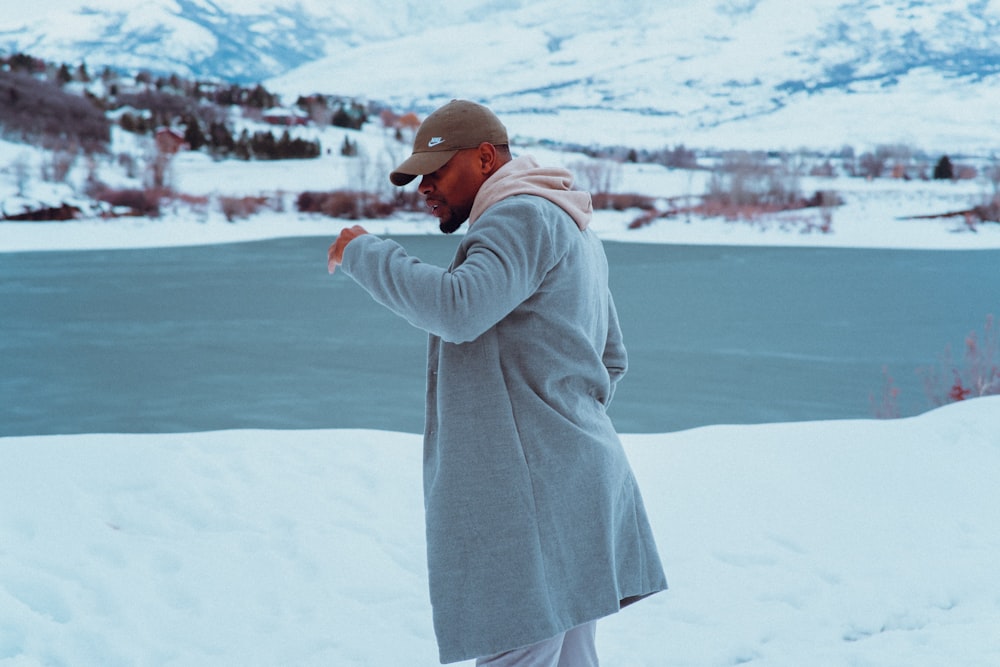 a man standing in the snow wearing a coat