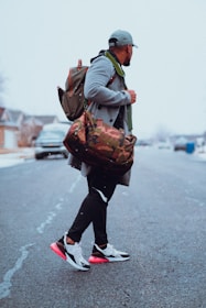 a man walking down a street carrying a bag