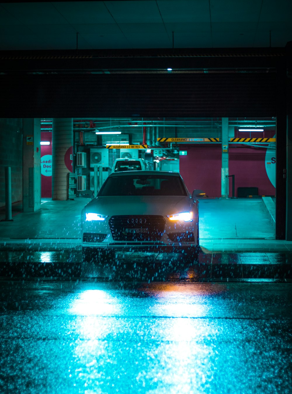 a car parked in a parking garage on a rainy night photo – Free Car Image on  Unsplash