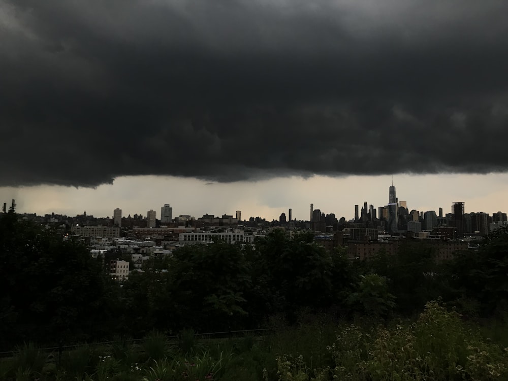 a city skyline under a dark cloud filled sky