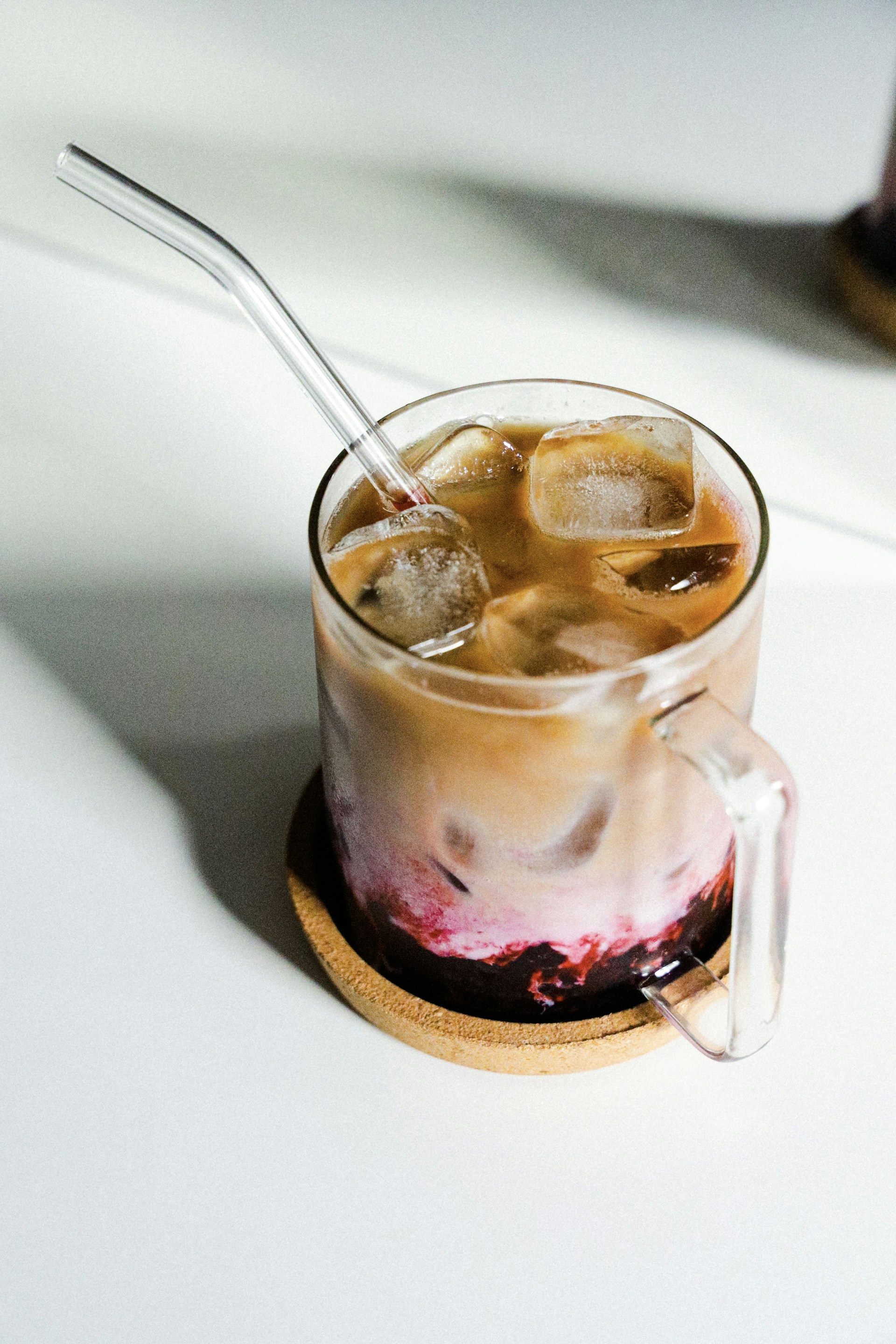 a glass of ice tea with a spoon in it
