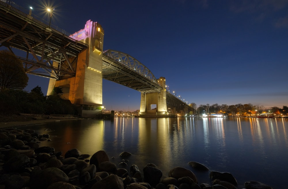 Un puente sobre un cuerpo de agua por la noche