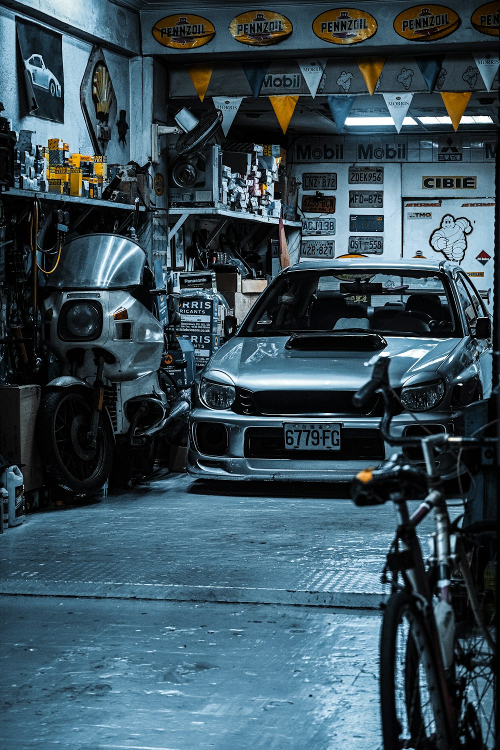 um carro estacionado em uma garagem ao lado de uma bicicleta