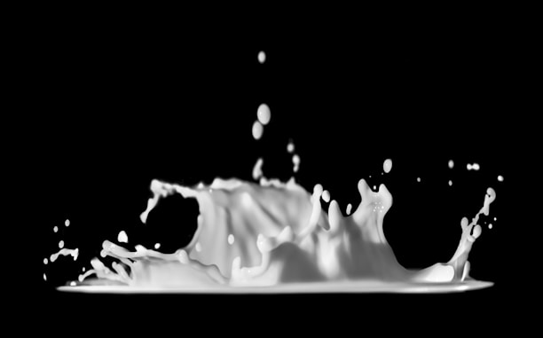 Dynamic, splashing liquid with droplets suspended mid-air, against a dark background.