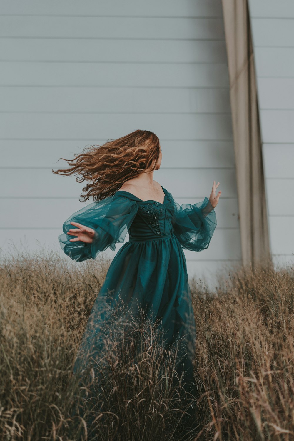 a woman in a green dress standing in a field