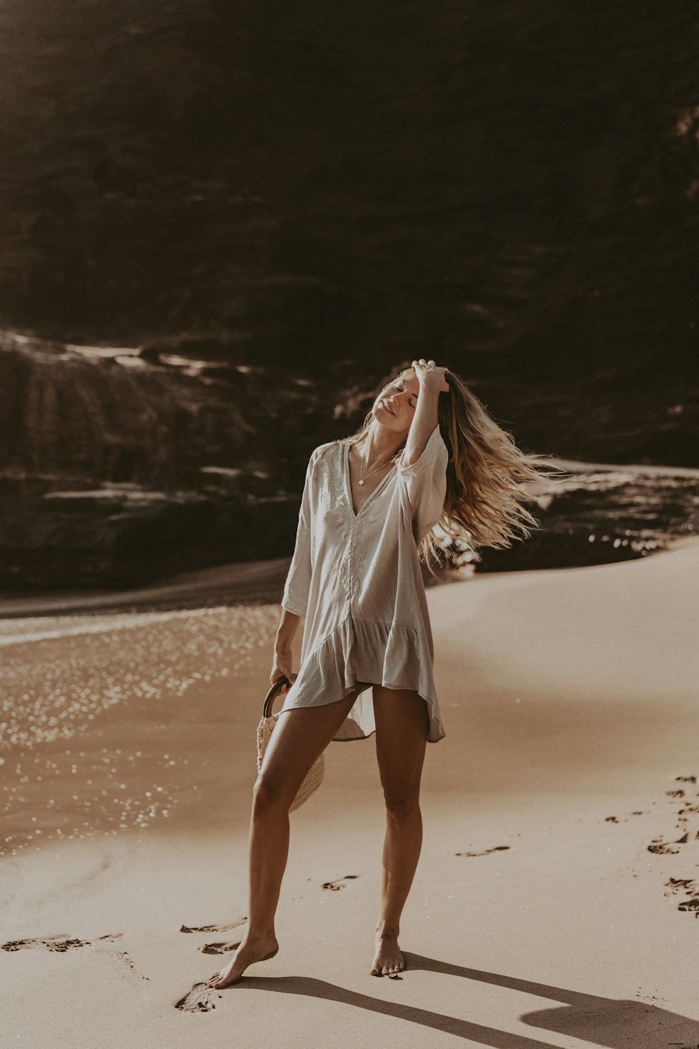 a woman standing on top of a sandy beach