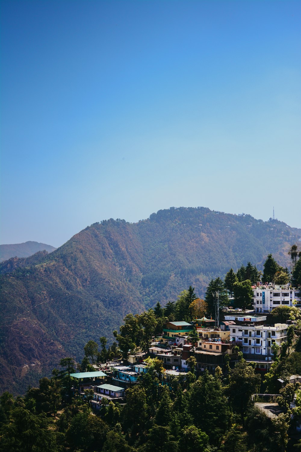 a village on a hill with a mountain in the background