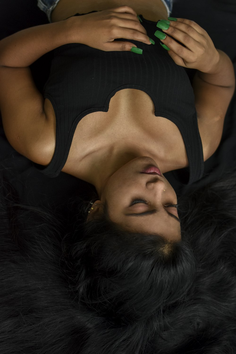 a woman in a black top laying on her back