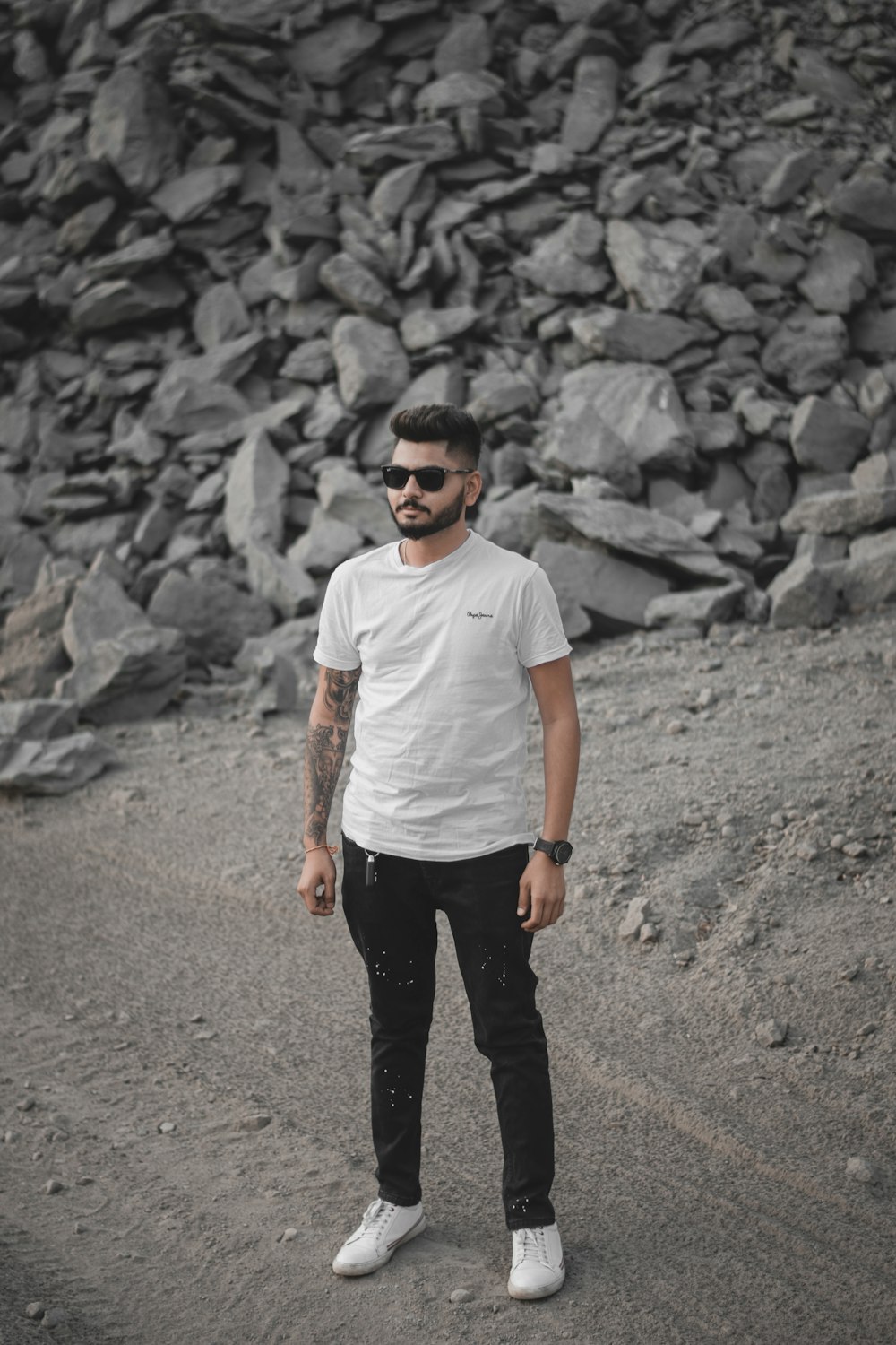 a man standing in front of a pile of rocks