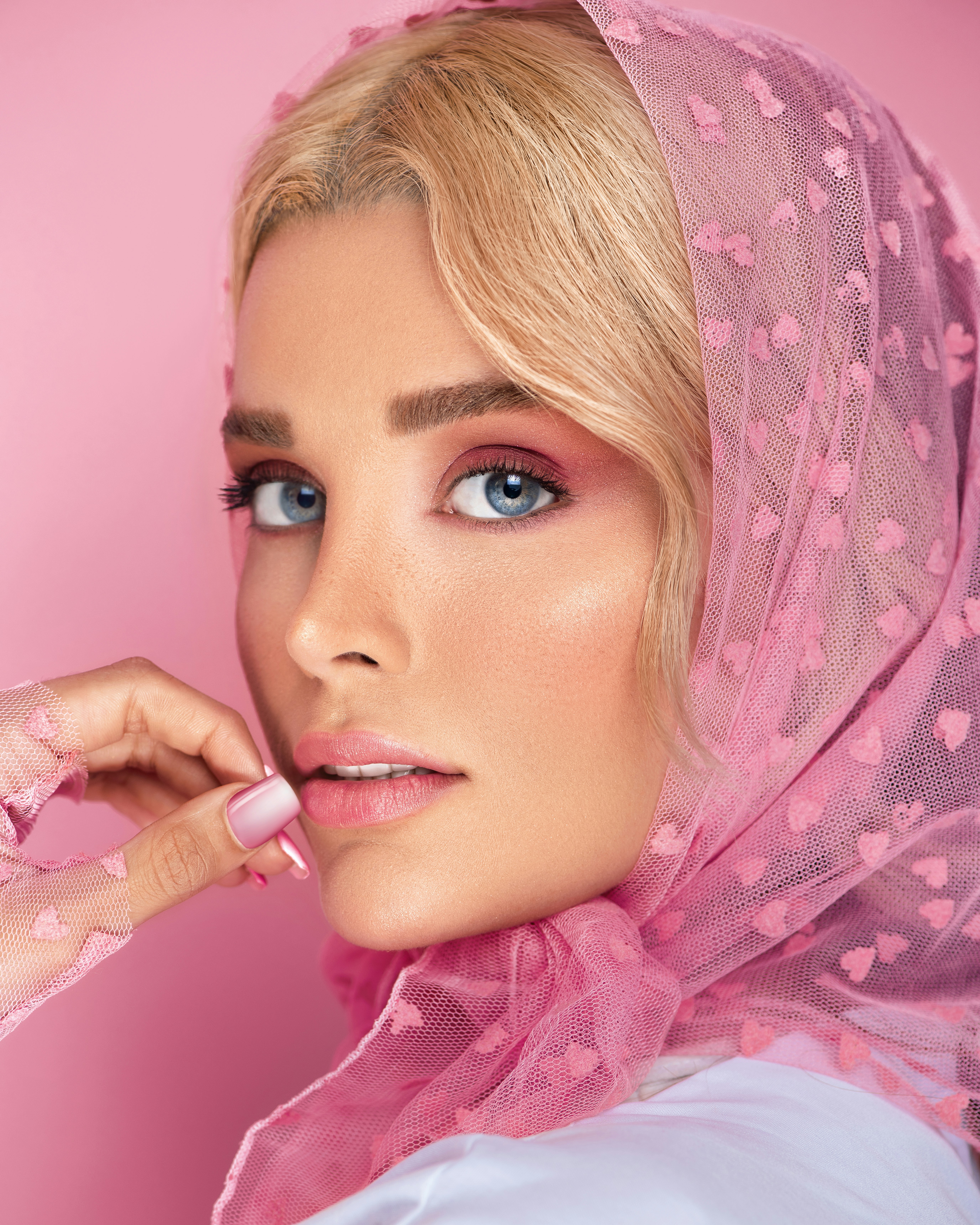 seorang wanita dengan syal merah muda di kepalanya