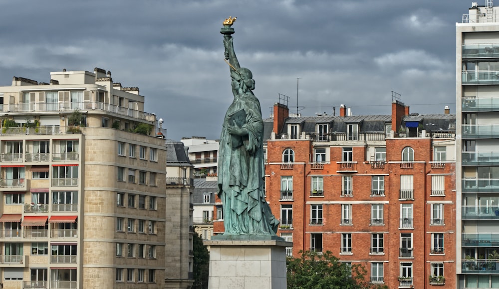 a statue of a woman holding a torch in a city