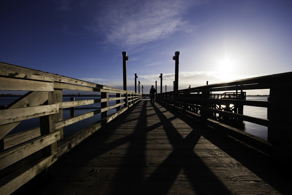 the sun is shining on a pier with poles