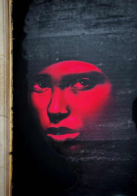 Close-up of a graffiti piece with vivid reds and blues, showing intricate brush strokes