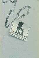 A weathered sticker is affixed to a rough-textured surface, depicting the silhouette of an adult holding hands with a child, next to a soccer ball. The words 'PASSION & FOOTBALL' are printed below the figures, suggesting a connection between family and the sport.