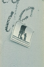 A weathered sticker is affixed to a rough-textured surface, depicting the silhouette of an adult holding hands with a child, next to a soccer ball. The words 'PASSION & FOOTBALL' are printed below the figures, suggesting a connection between family and the sport.
