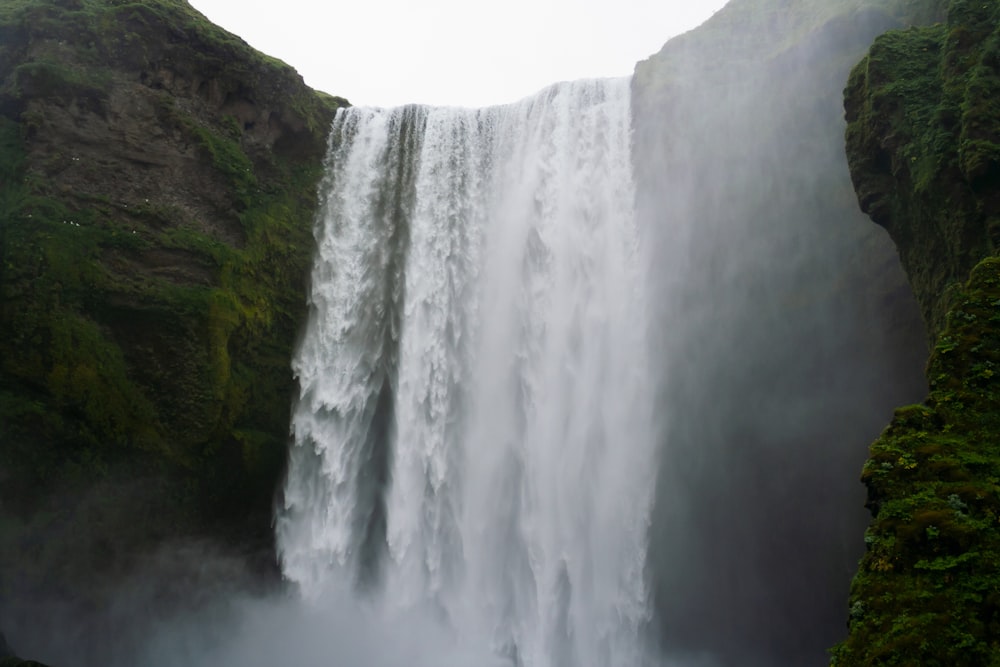 a large waterfall with water cascading down it's sides