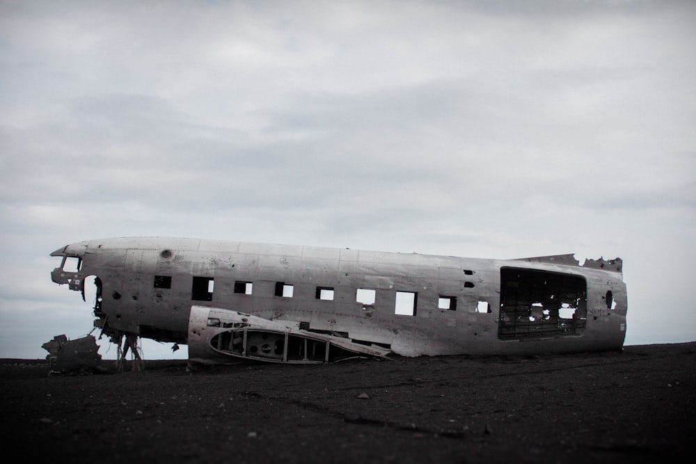 an old airplane sitting on top of a dirt field