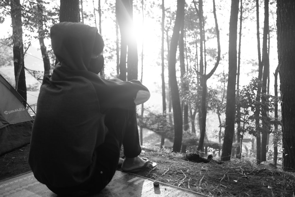 Una persona sentada en un banco en el bosque