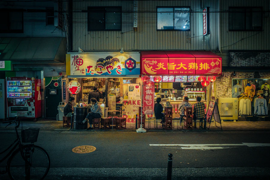 夜の駅前、灯りのついた店先