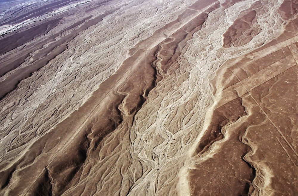 an aerial view of a desert with a plane flying over it