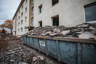 a dumpster full of rubble in front of a building