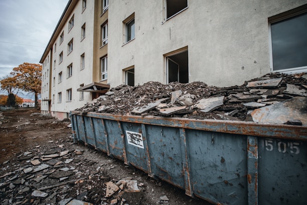 a dumpster full of rubble in front of a building