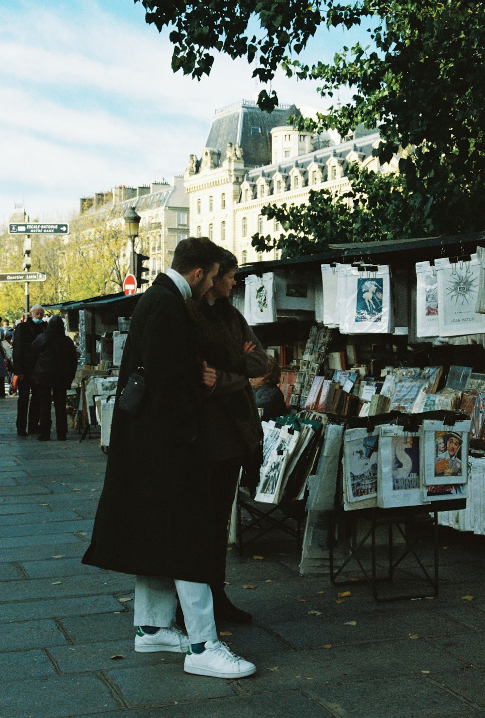 a man and woman standing next to each other on a sidewalk