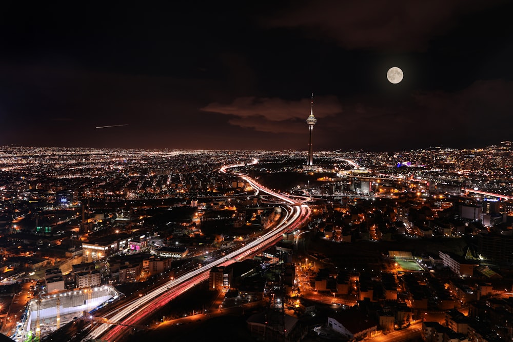 a view of a city at night with a full moon