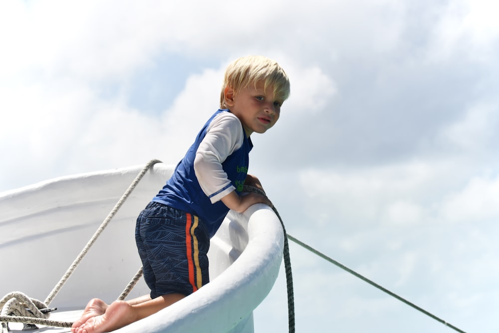 a young boy standing on the edge of a boat