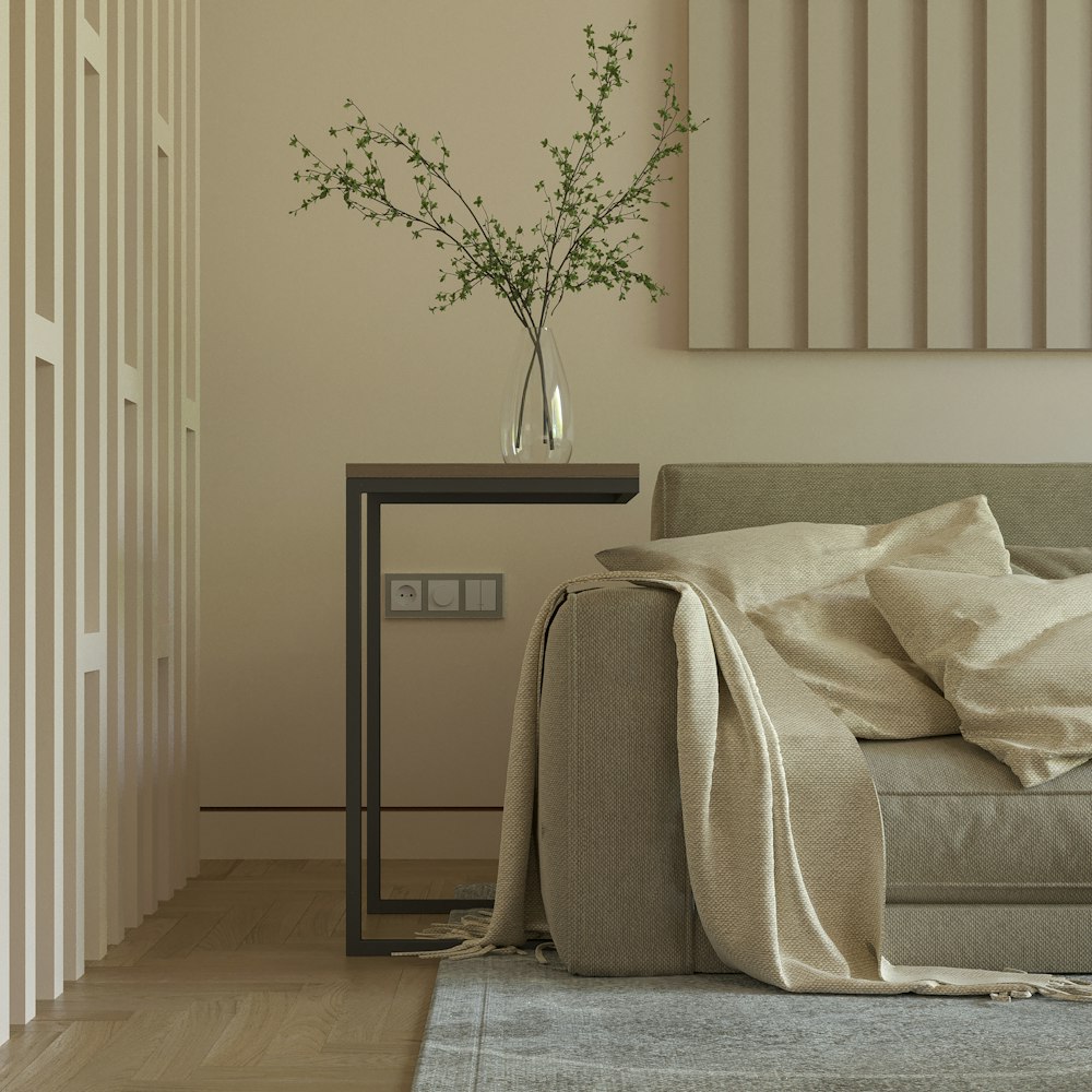 a living room with a couch and a table with a vase on it