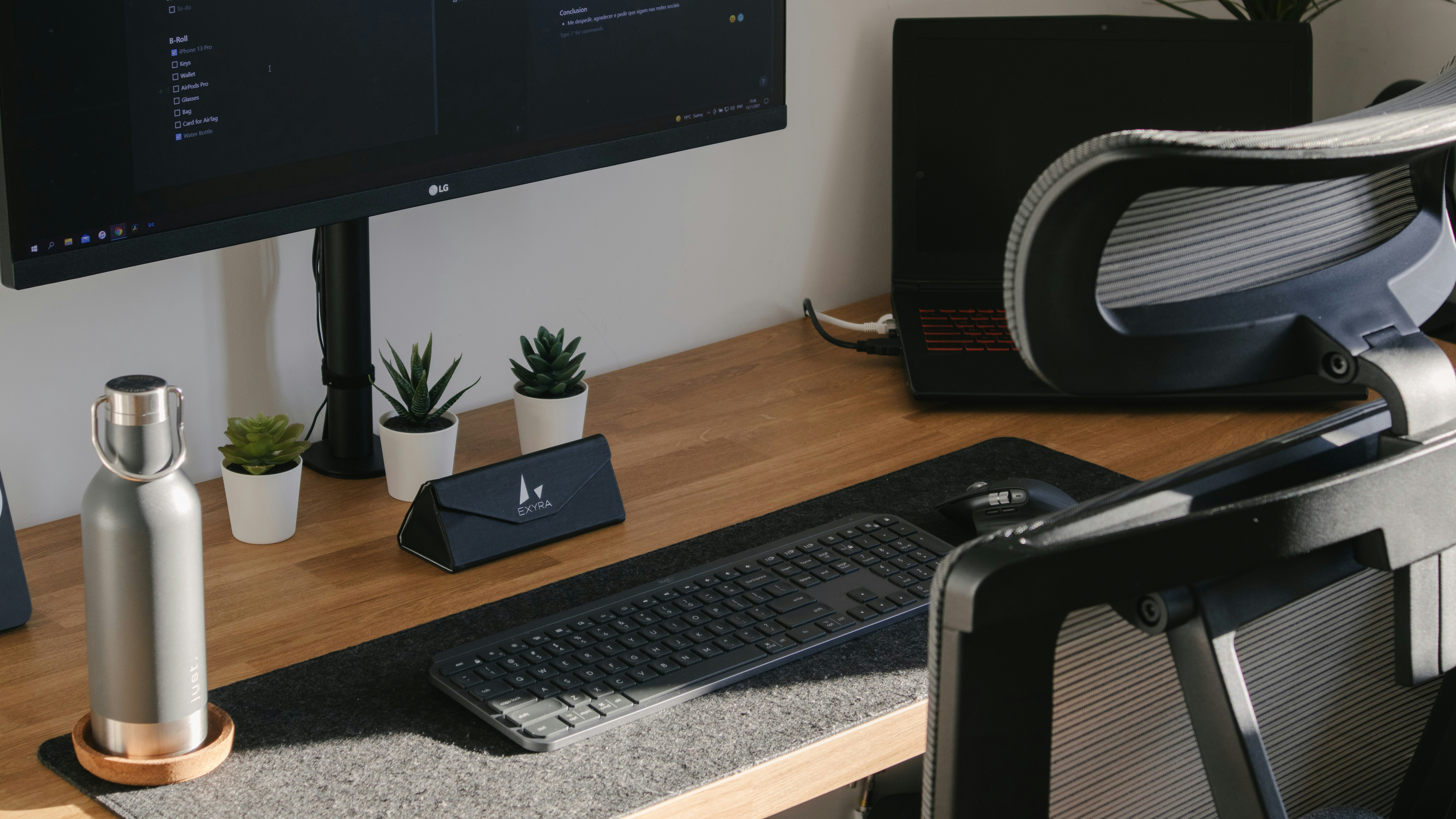 A clean, minimalist desk setup featuring an open laptop, a cup of coffee, and a set of house keys, representing a realtor's digital workspace.
