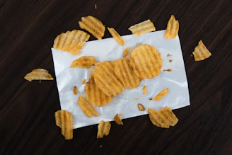 An assortment of premium UK crisp packets arranged on a rustic wooden table.