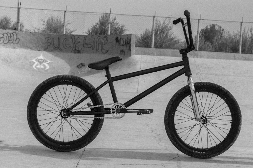 uma foto em preto e branco de uma bicicleta em um parque de skate