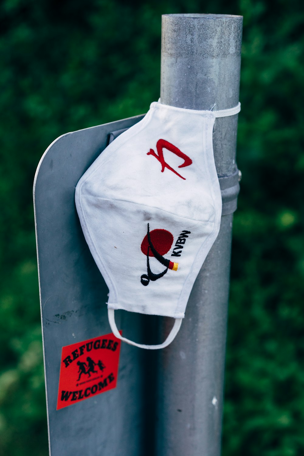 a white face mask hanging on a metal pole