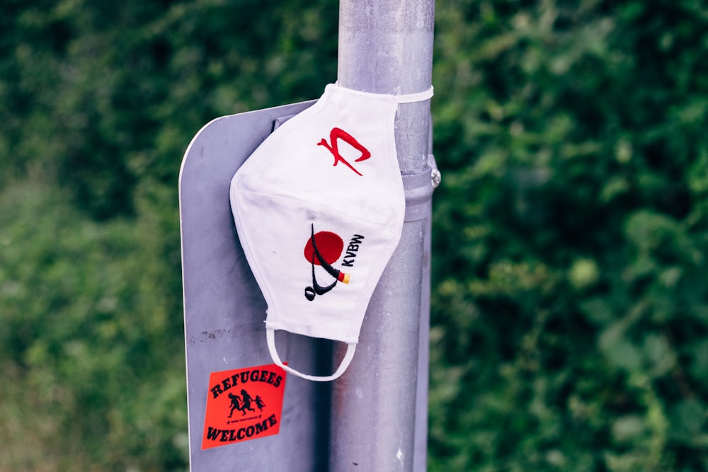 a white face mask hanging on a pole