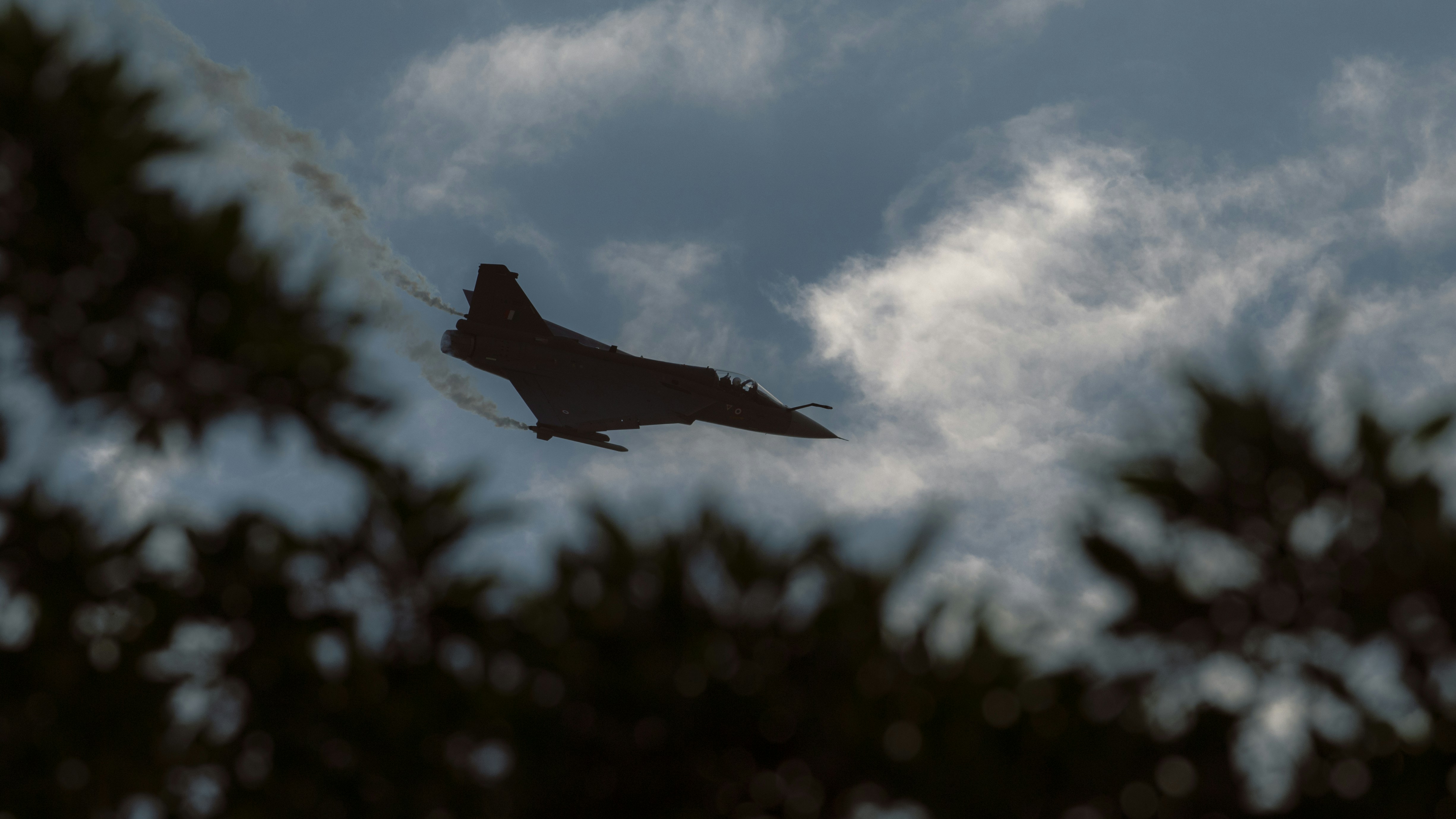 a fighter jet flying through a cloudy sky, Dubai airshow 2021.