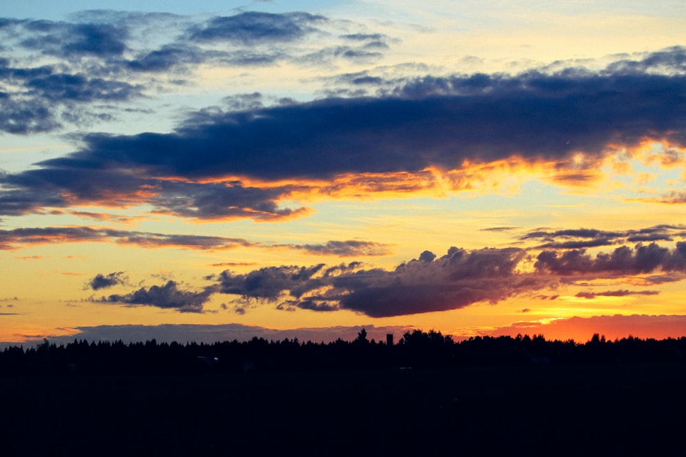 a plane is flying in the sky at sunset