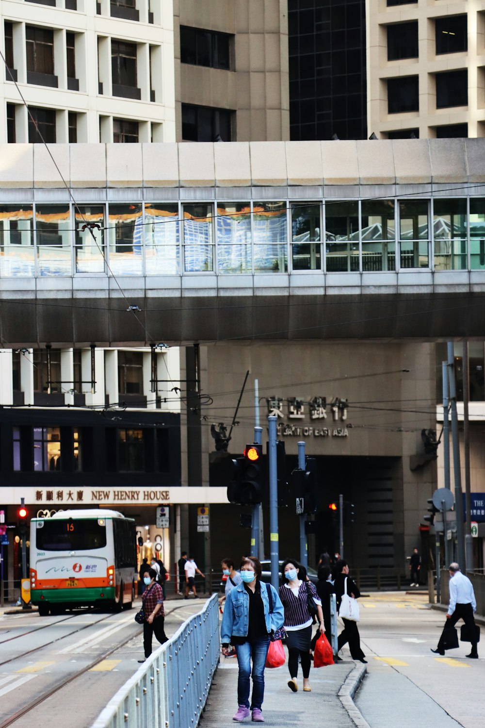 a group of people walking across a bridge over a street