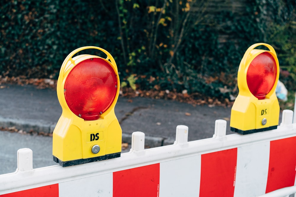 a couple of yellow traffic lights sitting on the side of a road