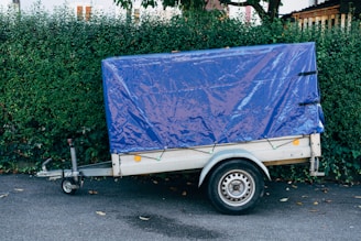 a trailer with a blue tarp on the back of it