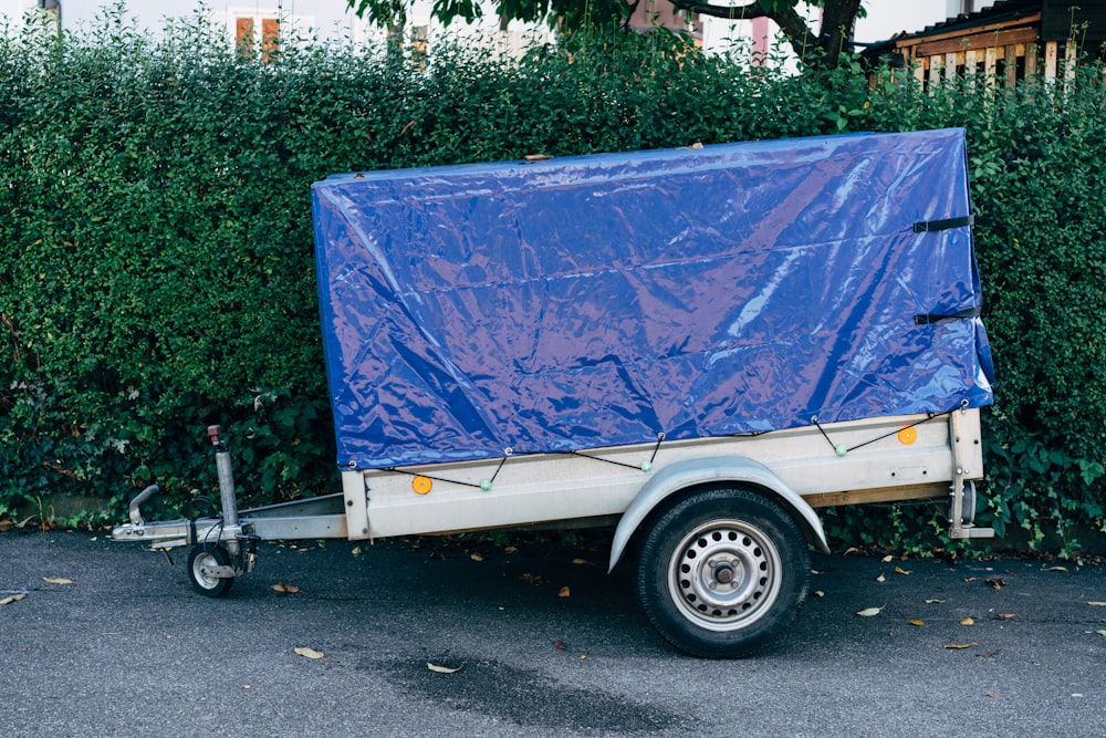 a trailer with a blue tarp on the back of it