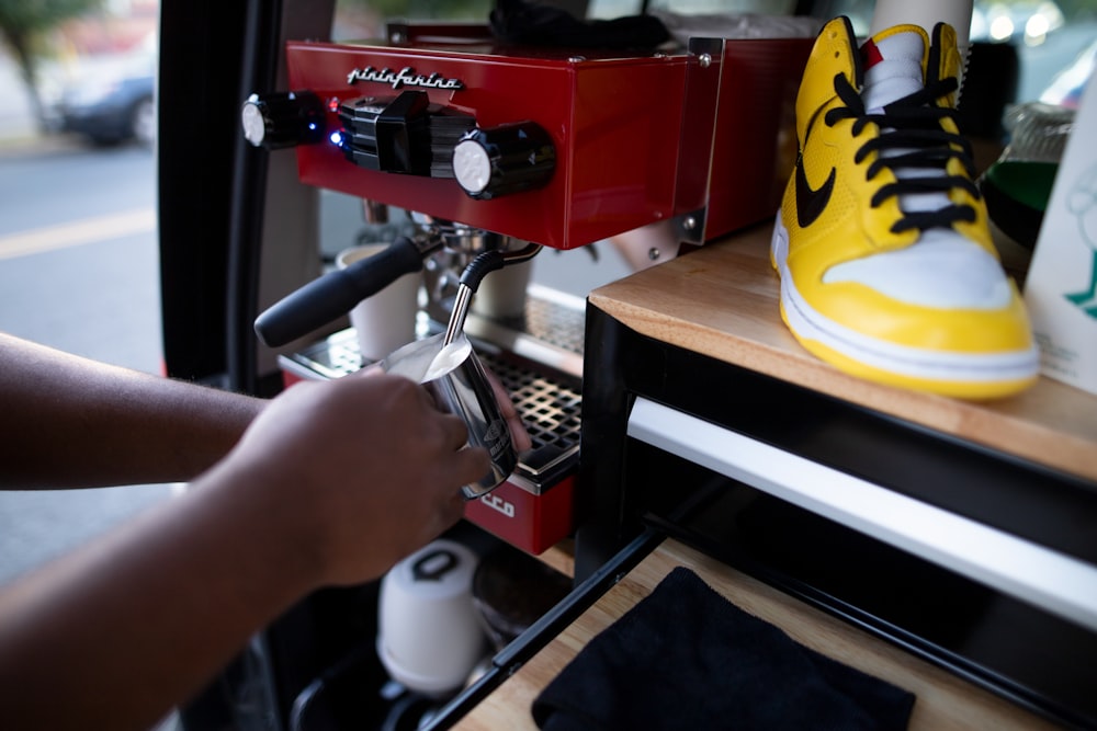 a person using a coffee machine to make a cup of coffee