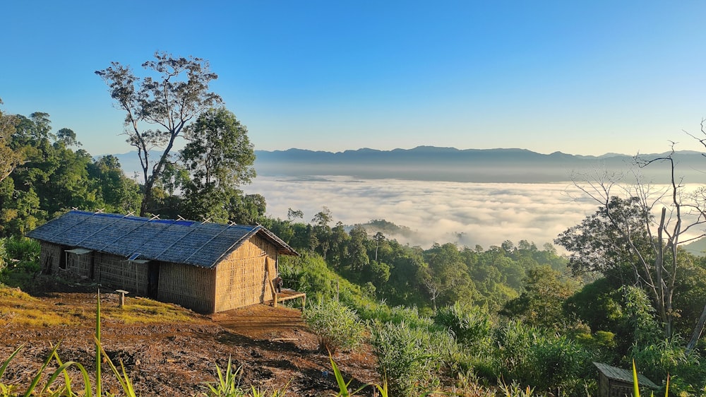 a small cabin on a hill above the clouds