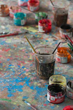 a table topped with lots of paint and brushes