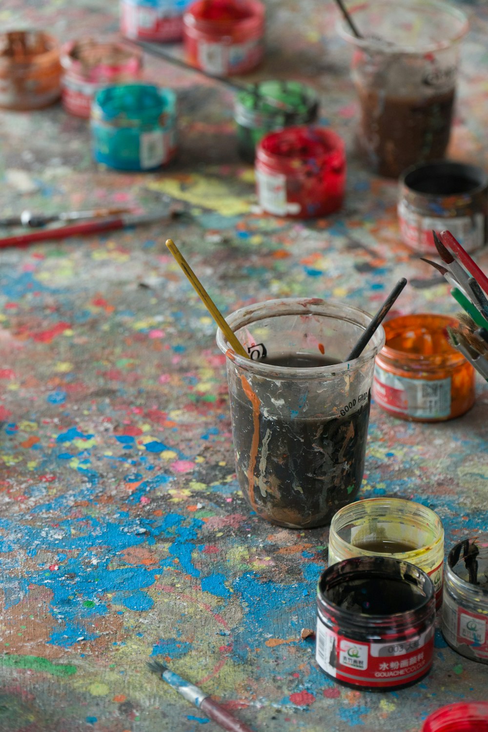 a table topped with lots of paint and brushes