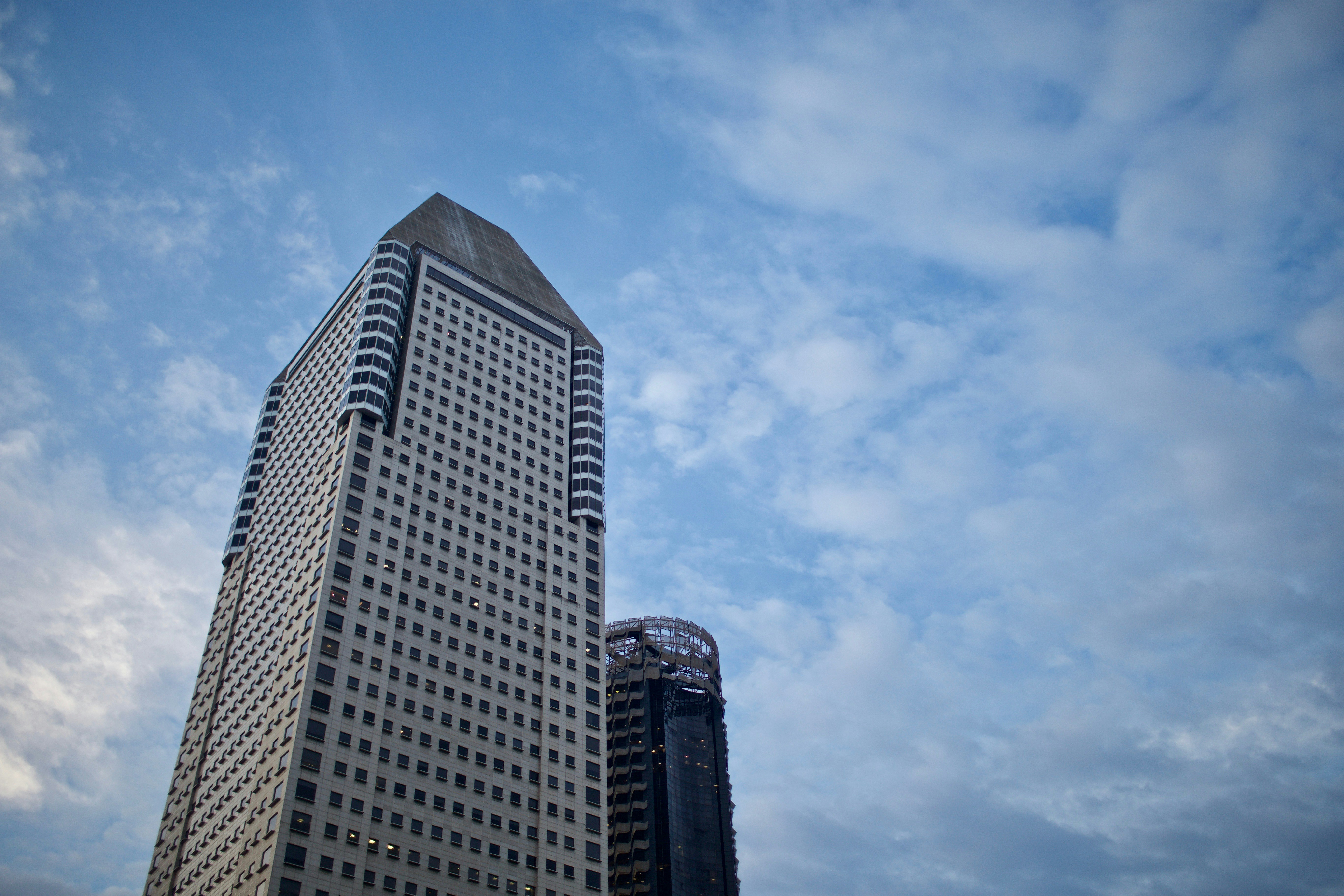 a very tall building sitting under a cloudy blue sky